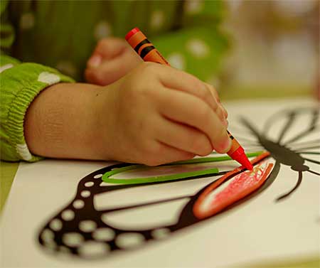 child coloring a butterfly