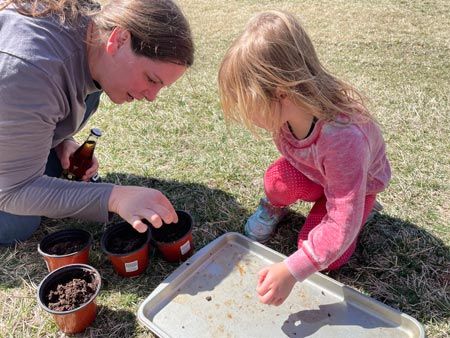 Mom Helping Her Daughter Plant Seeds