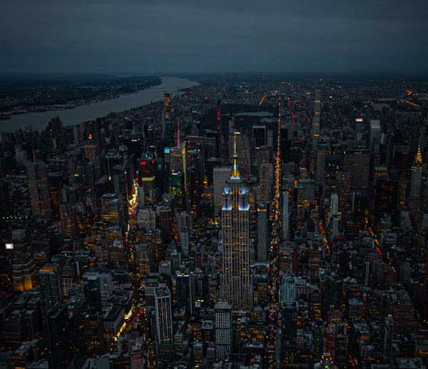 eco friendly building | Gardens with Wings Aerial night view of a dense city skyline with illuminated skyscrapers and a river in the distance.