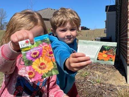 Kids Holding Seeds for Butterfly Plants