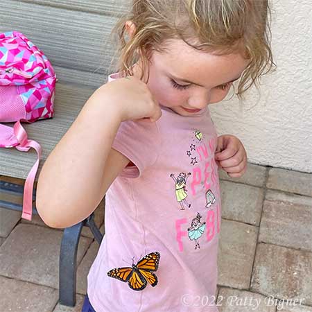 child releasing monarch butterfly