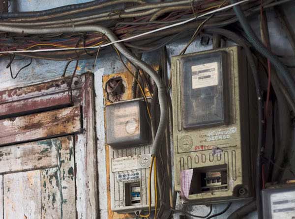 old electric wiring | Gardens with Wings Old electricity meters with tangled wires mounted on a worn wall.