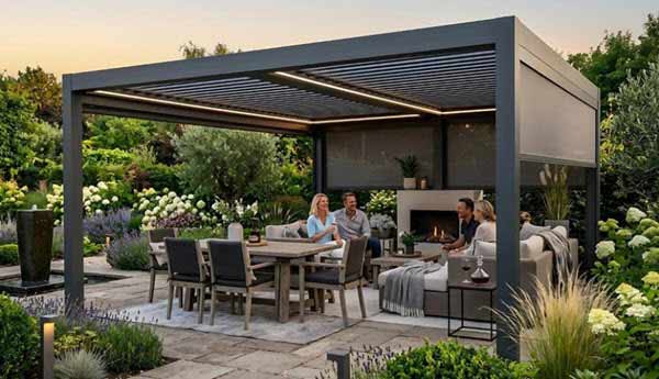 patio shade | Gardens with Wings Modern outdoor living space under a dark pergola with a dining table, lounge seating, and a built-in fireplace as people chat at sunset.