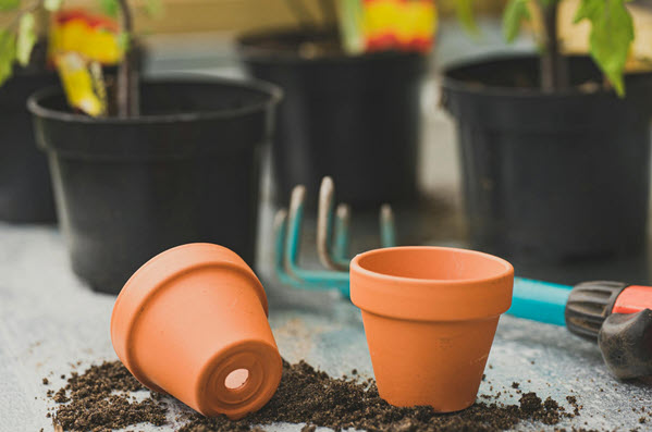 pots | Gardens with Wings Gardener arranging potted plants and tools to establish a new garden